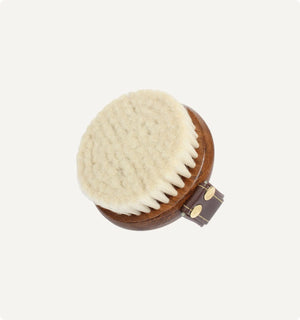 Round wooden brush with natural bristles on a white background